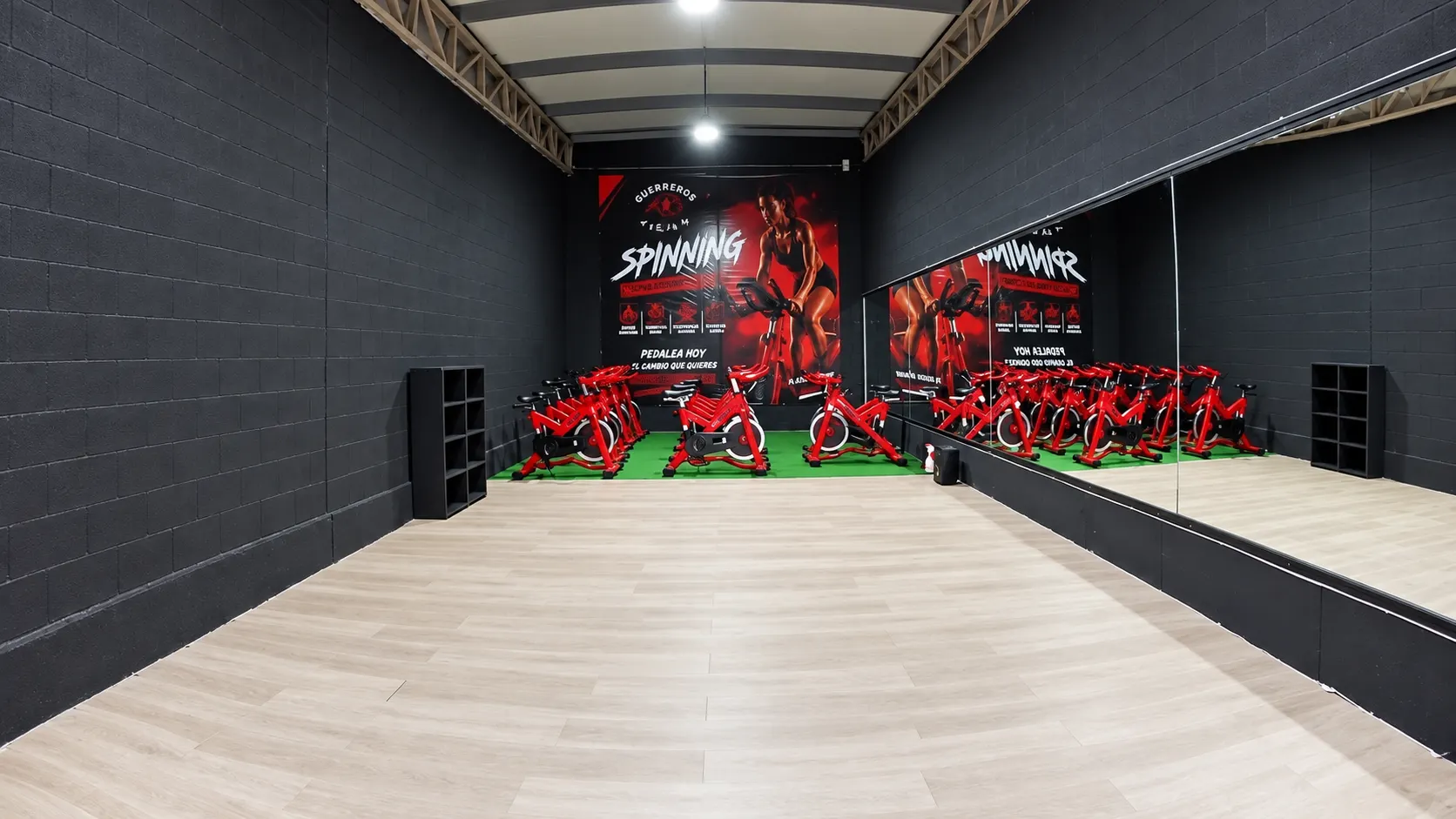 Sala de spinning de Guerreros Jazar con bicicletas rojas y mural