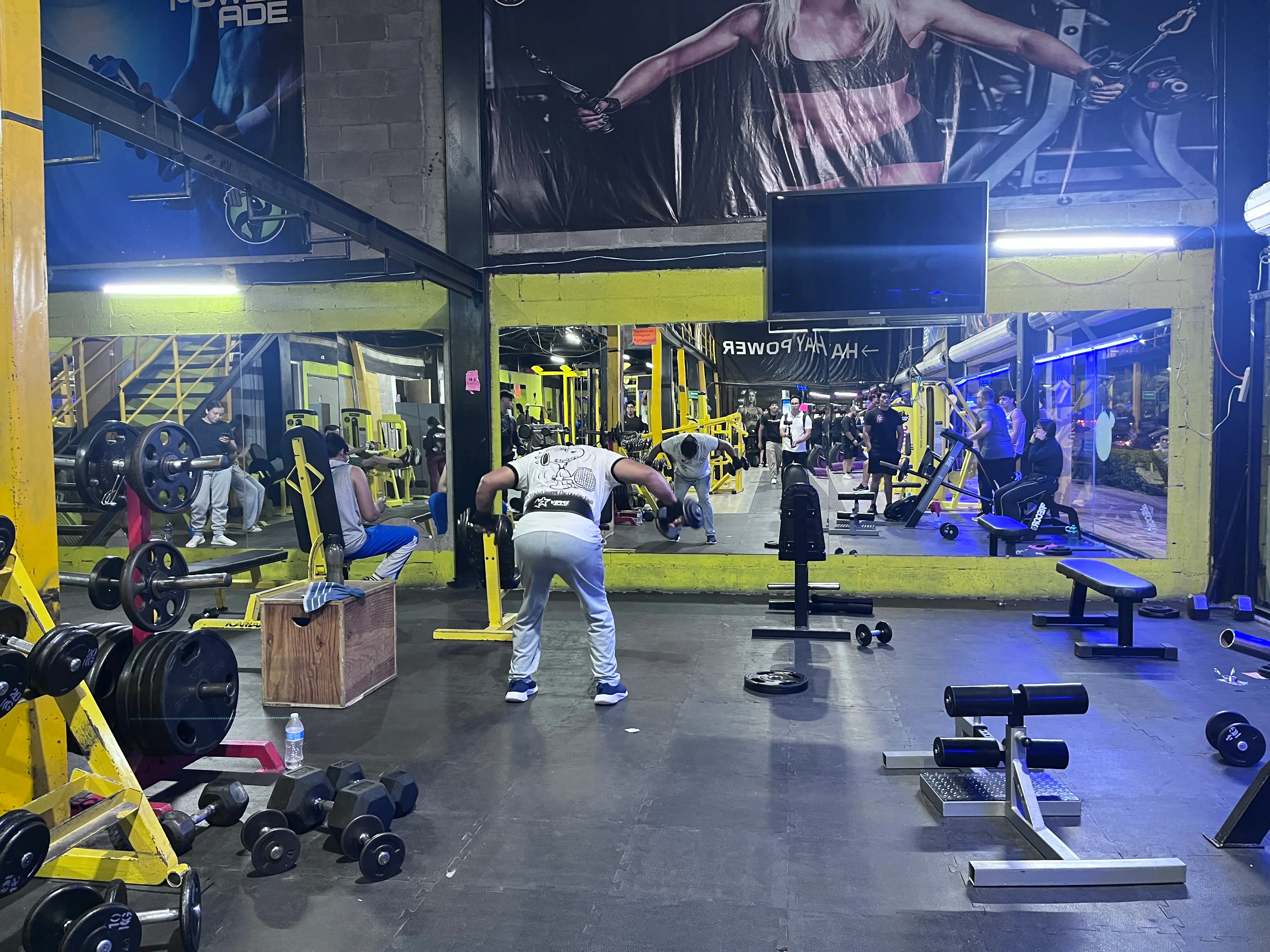 Gente entrenando fuerza en el piso de pesas de Gym & Fitness Jazar, Villa Sur