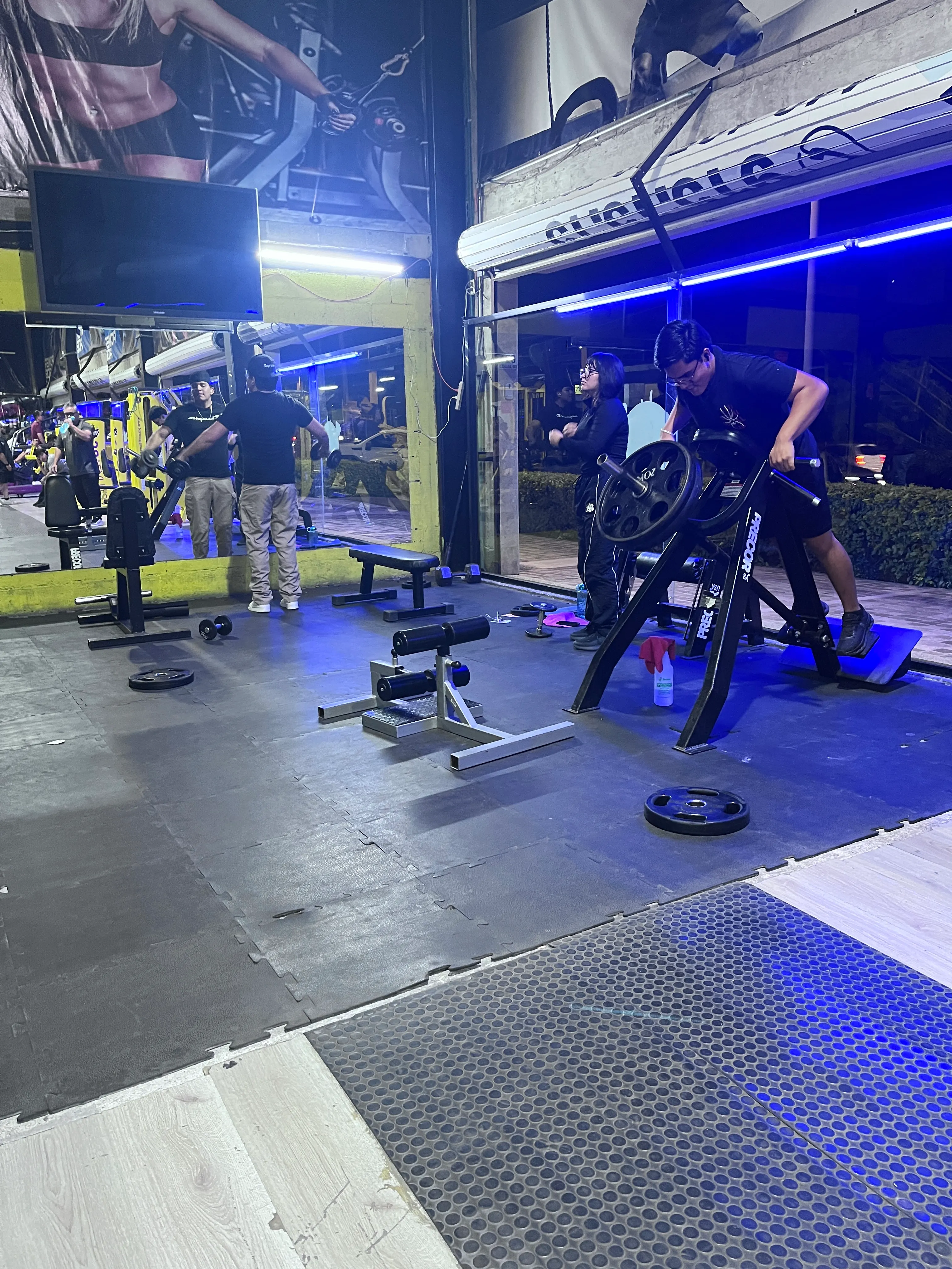Zona junto a ventanales en Gym & Fitness Jazar, Villa Sur, con gente entrenando en máquinas